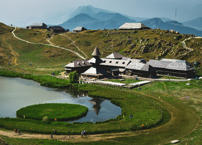 a house on a hill with a lake in front of it